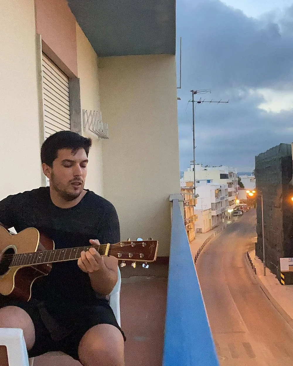 Diogo Carvalheiro a tocar guitarra na varanda, ao fim do dia, em Armação de Pêra
