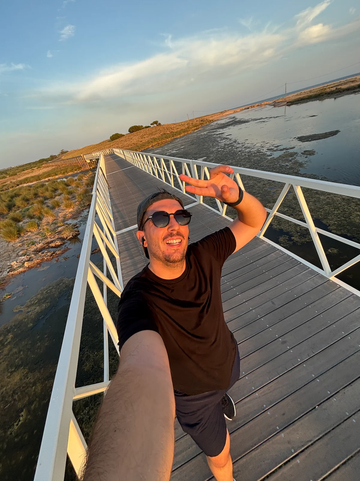 Diogo Carvalheiro num passadiço sobre a ria, ao pôr do sol, no Algarve
